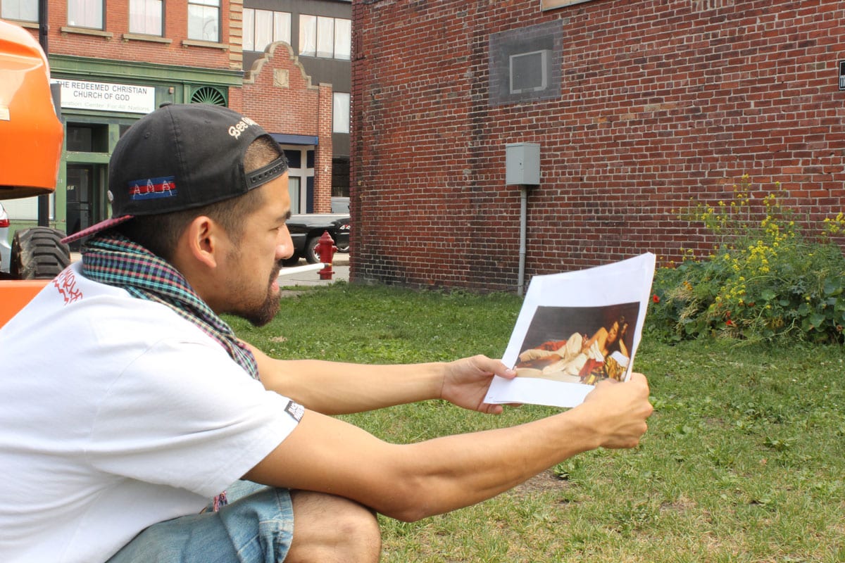 >FONKi of Cambodia/Montreal counts bricks to scale his mural for the 1,708 square foot canvas of 22 Munroe St. 