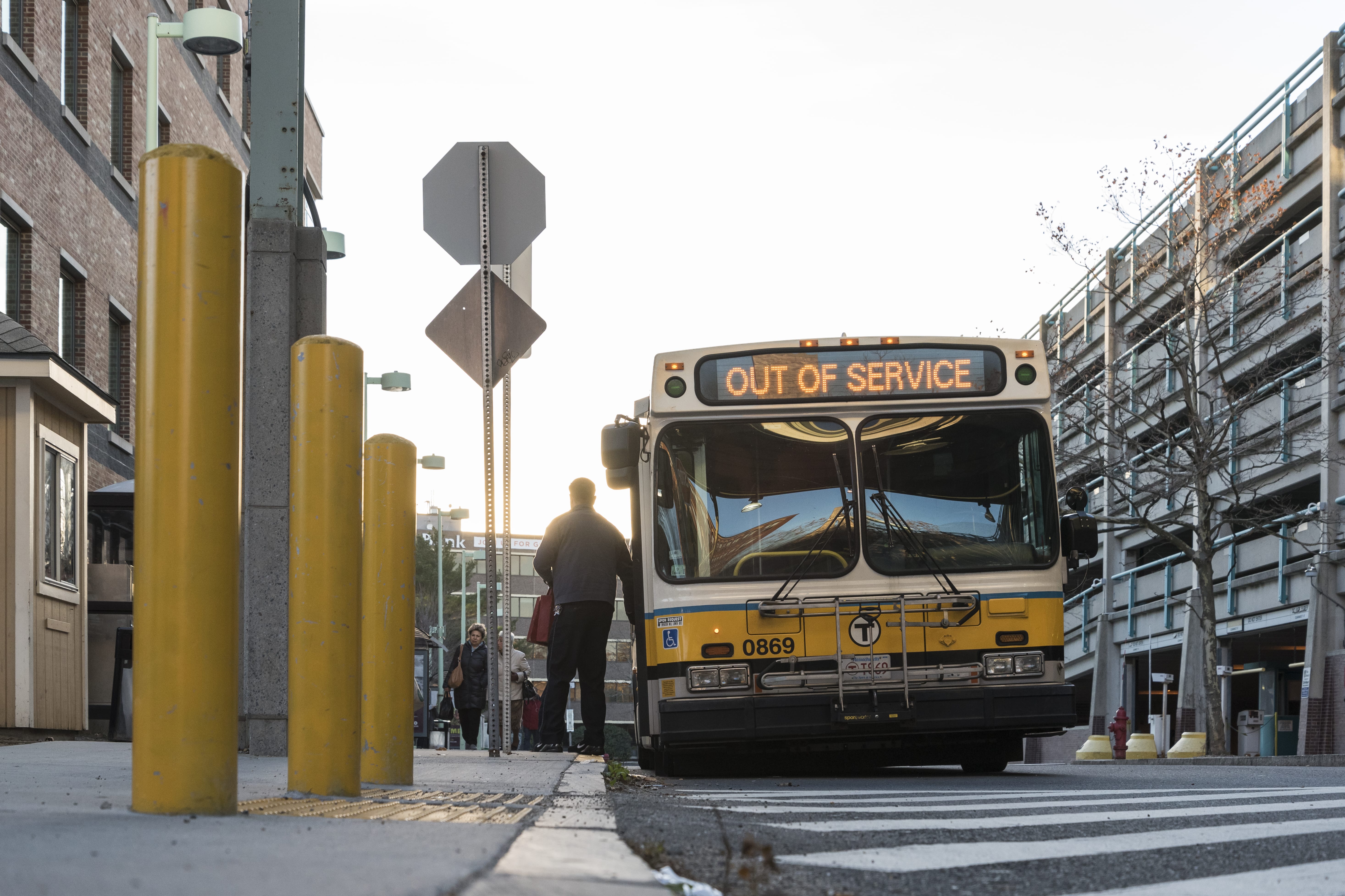 A bus driver climbs out of his bus at Central Square Station in Lynn.