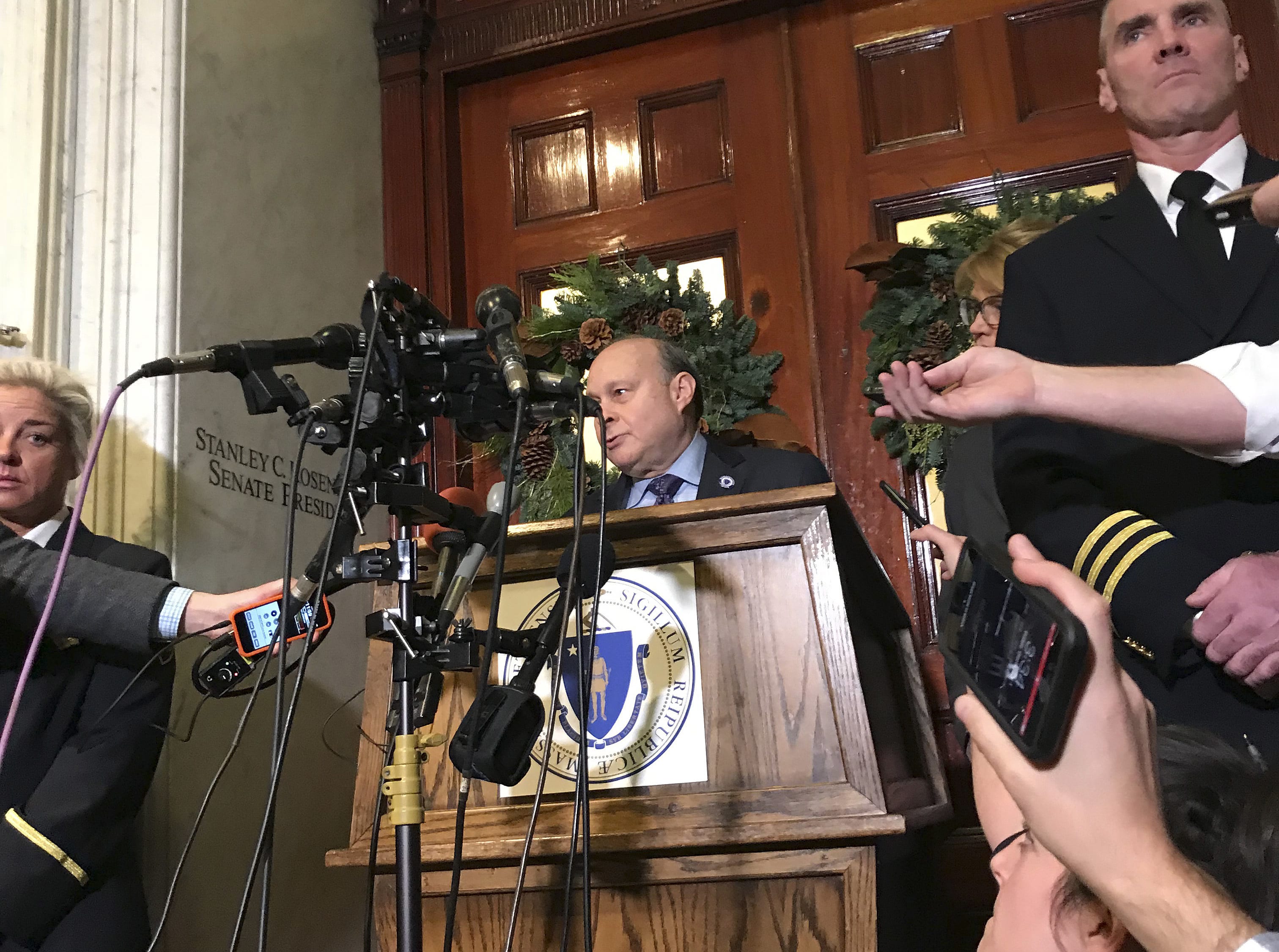 Massachusetts Senate President Stan Rosenberg speaks from behind a podium outside his office at the Statehouse to a throng of media Friday, Dec. 1, 2017, in Boston.