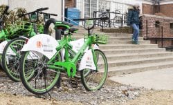 A woman leaves Swampscott Public Library and walks past ANT Bicycles parked out front.
