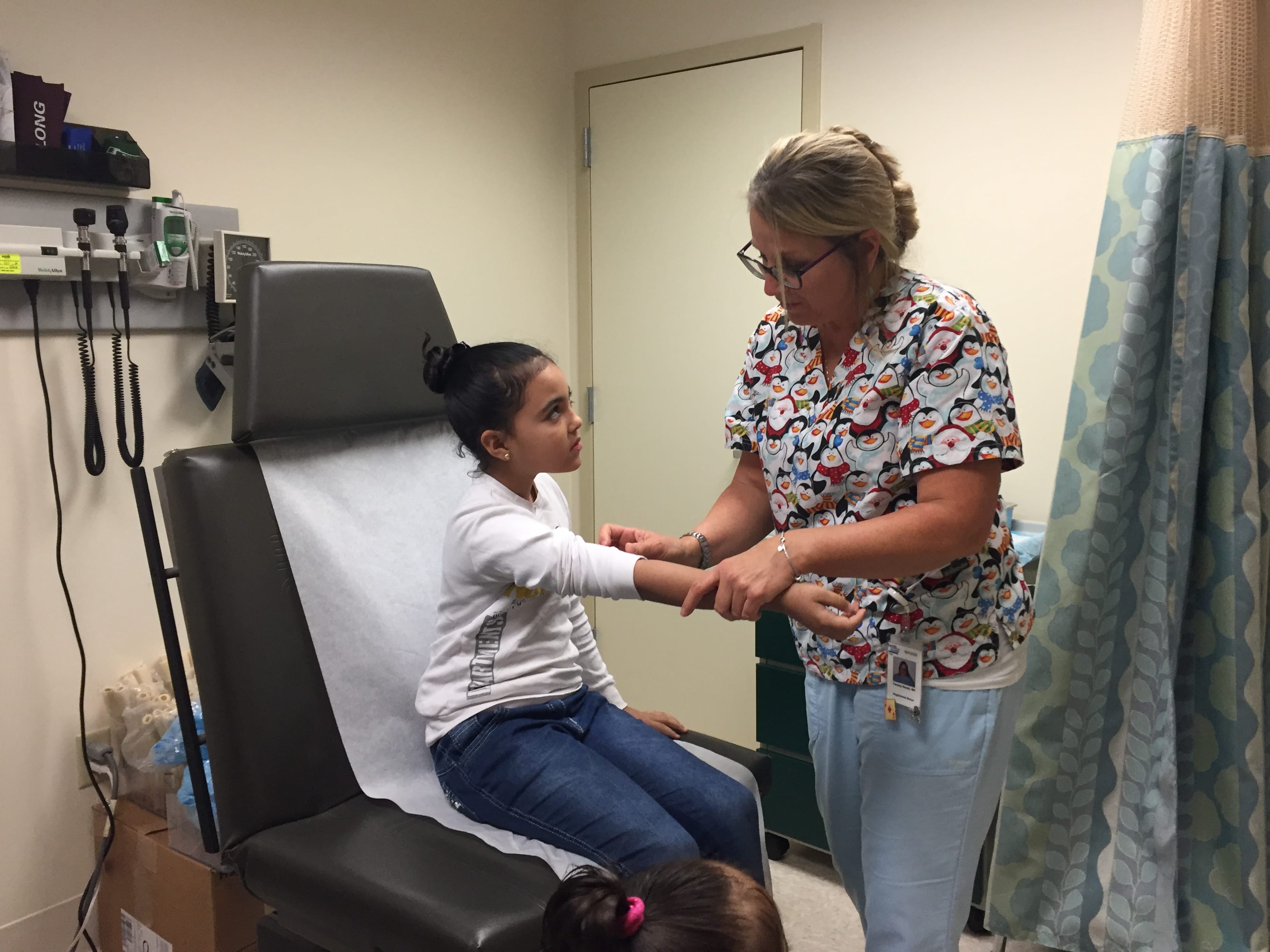 Lynn Community Health Center registered nurse Tammy Sands gives a child a flu shot.