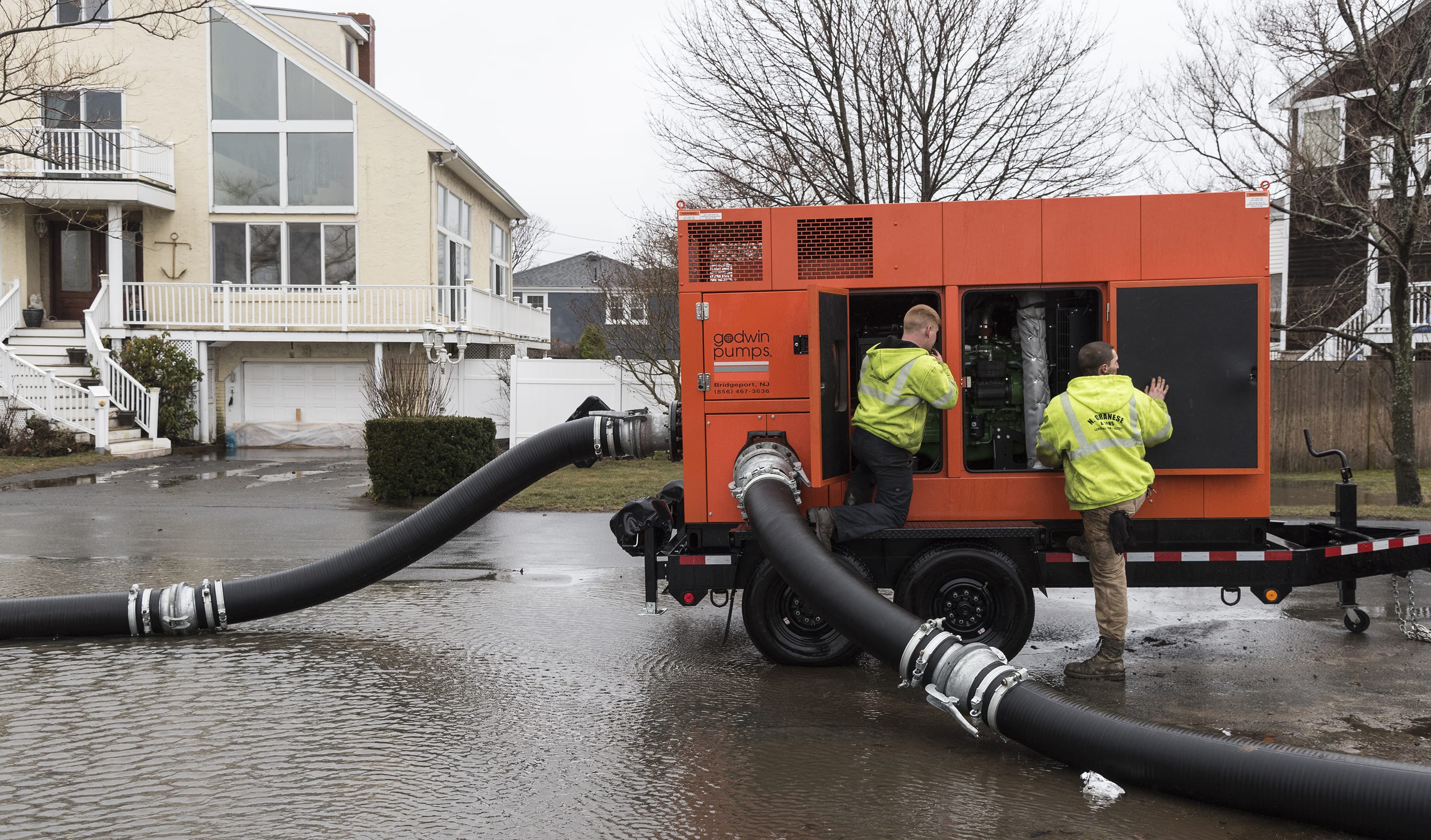 N. Granese & Sons General Contractors employees Jon McCarriston of Haverhill, left, and Bill Chalmers of Rockport work to get a pump going to remove water from Ward Road in Nahant.
