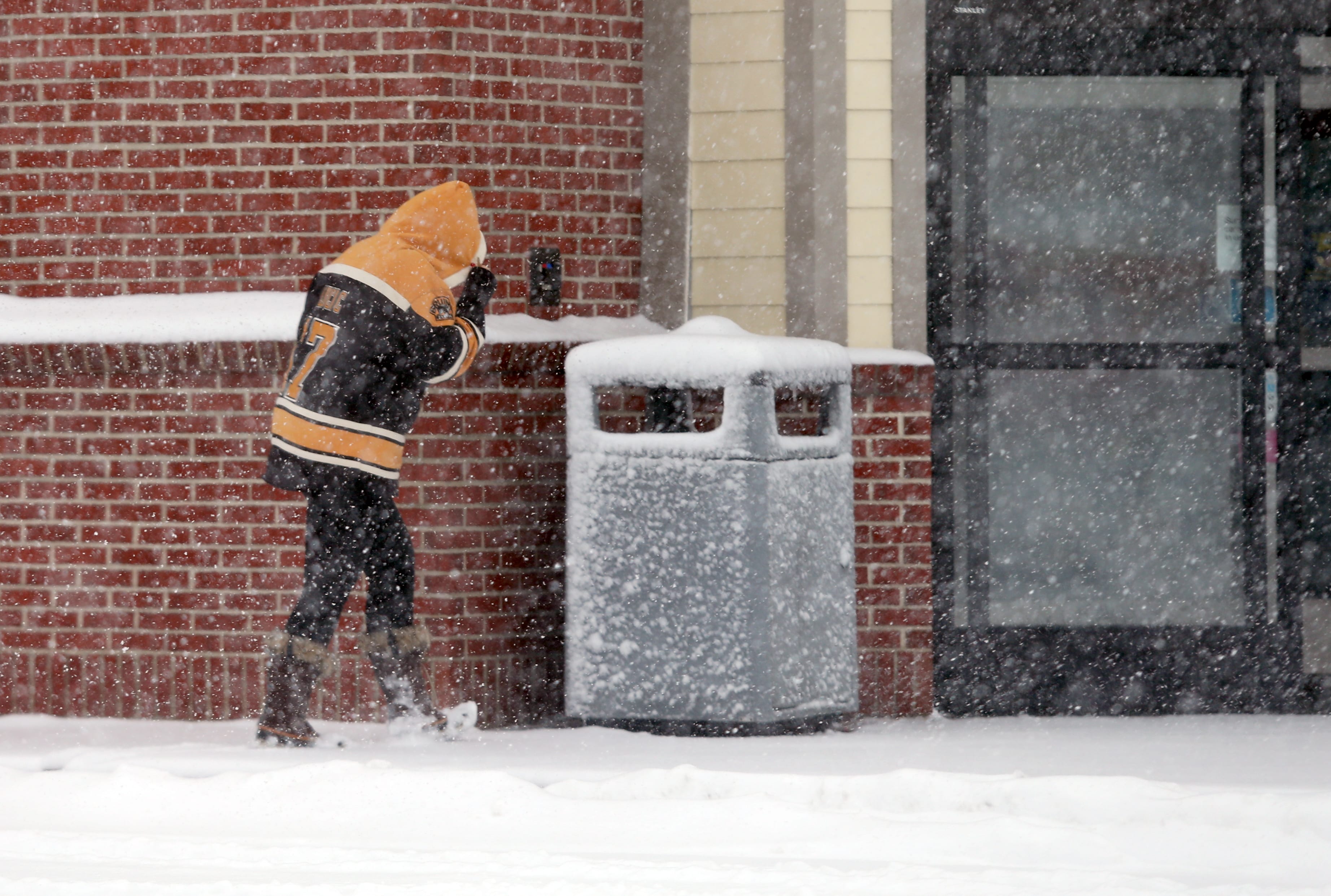 Lynn, MA—Tue March 13, 2018—Shopper at CVS on Boston Street Lynn shields face from blowing snow during the Tuesday storm.