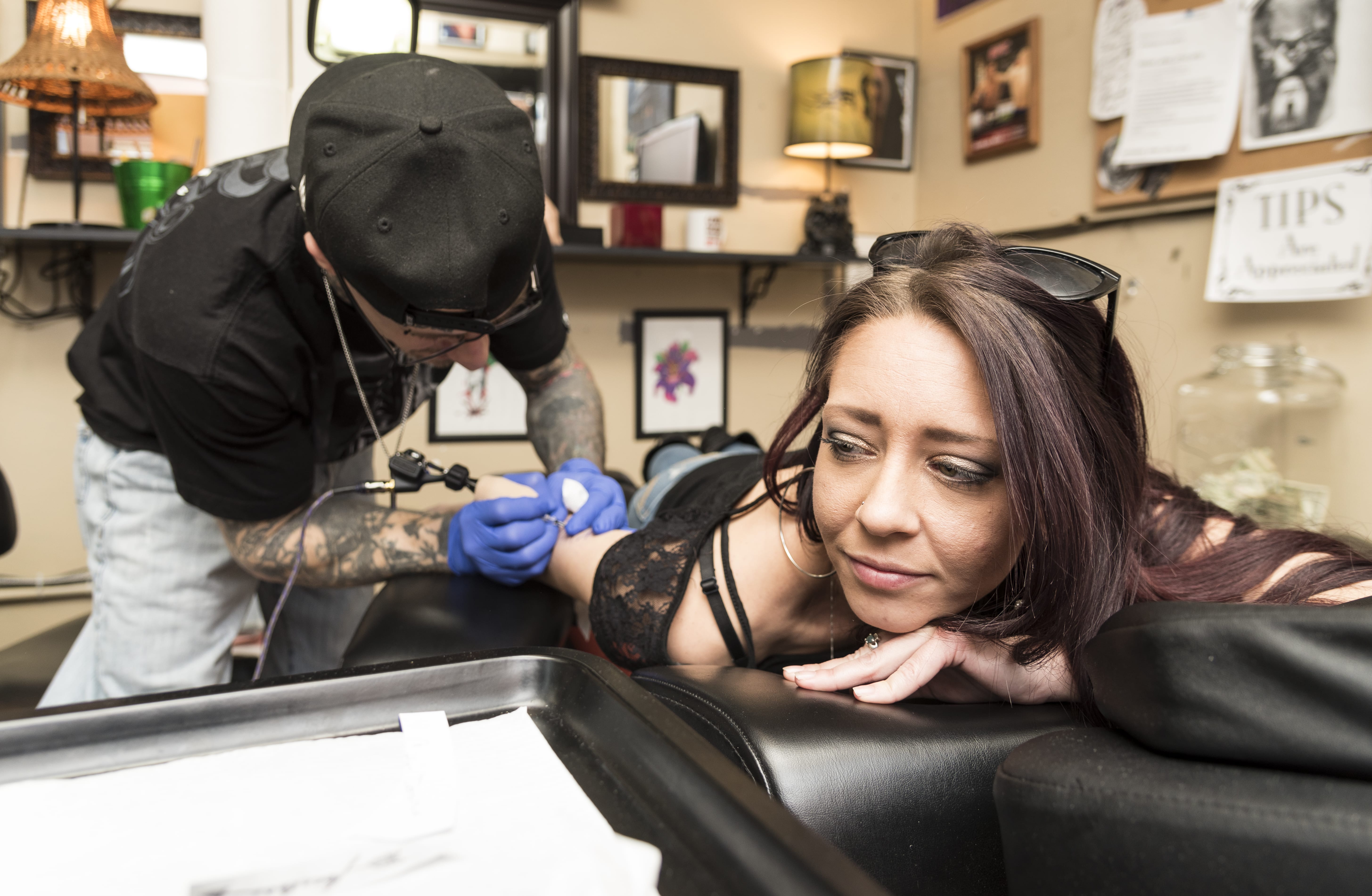 Tattoo artist Jared Breault of Salem gives Caitlin Donahue of Woburn some new ink at 7 Deadly Sins Tattoo in Lynn during the shops Friday the 13th special.