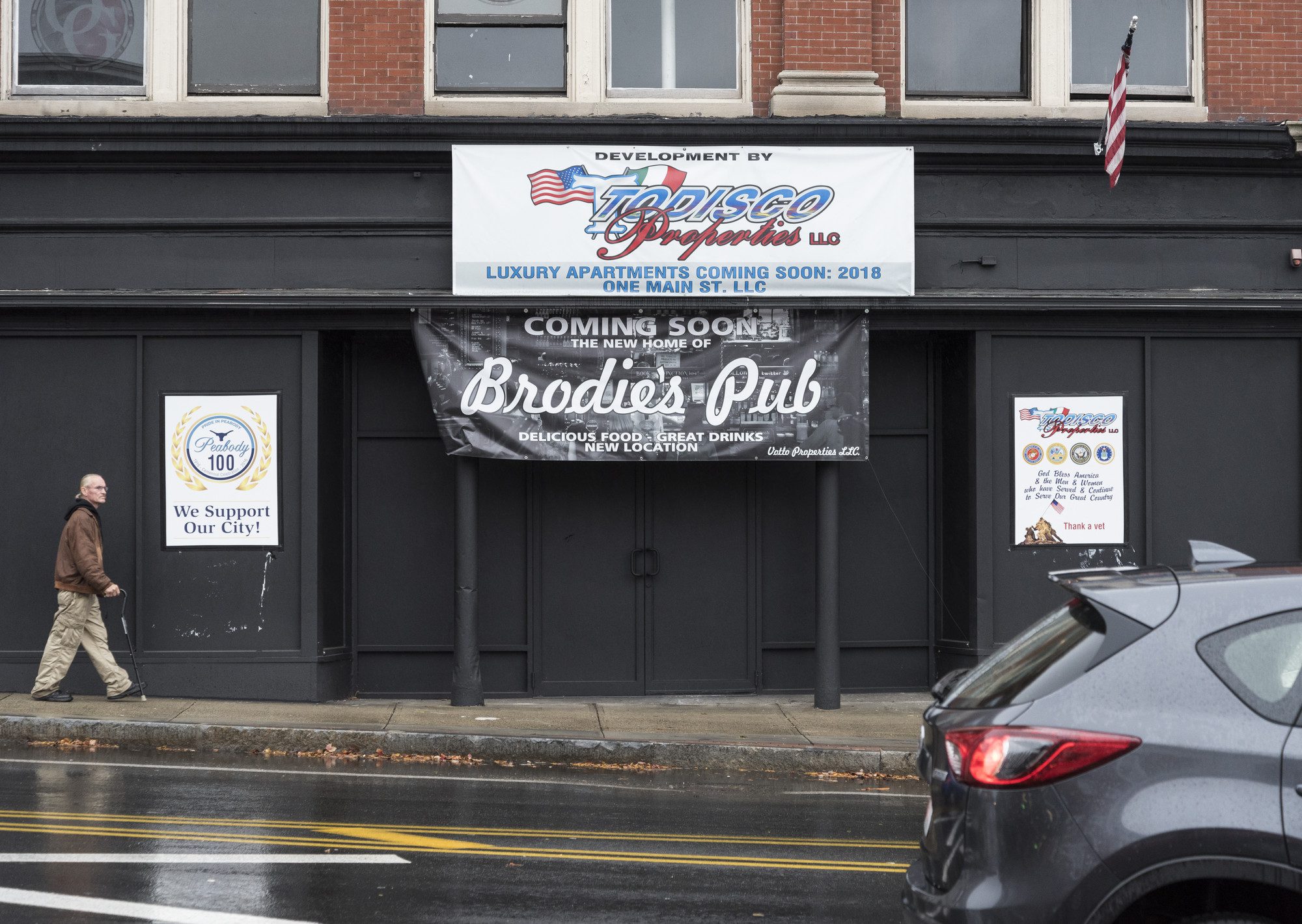 A pedestrian walks past the future site of Brodie's Pub on Main Street in Peabody.