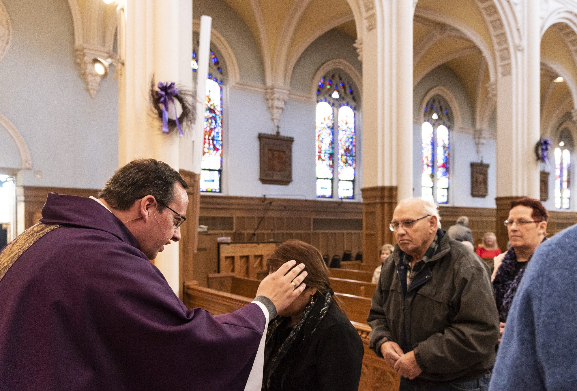 Parishioners receive their ashes from Fr. Robert Poitras during Mass on Ash Wednesday at St. Pius V Church.