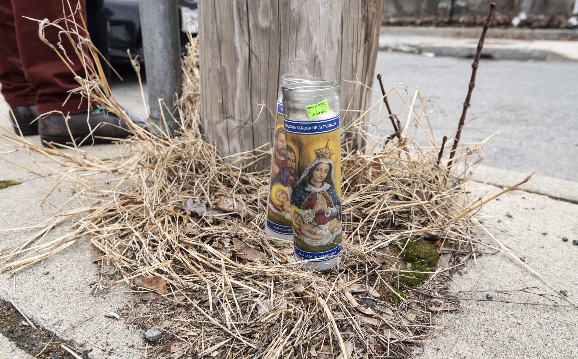Prayer candles rest at the base of a telephone pole on Williams Avenue in Lynn where Anthony Betancourt was shot and killed early Wednesday morning.