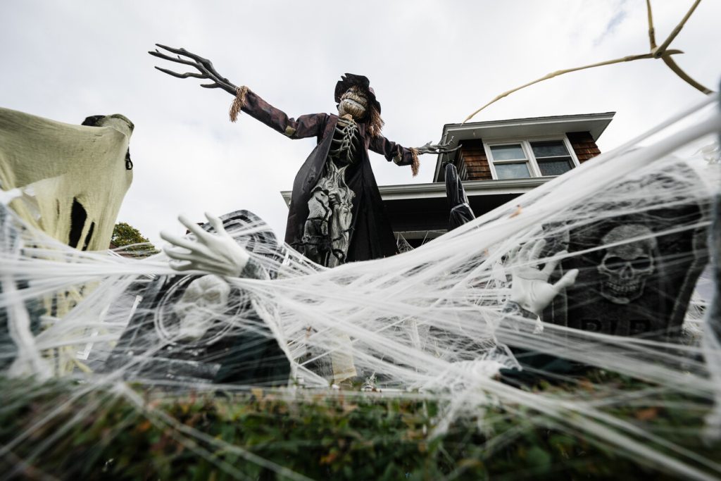 A giant scarecrow stands watch over the haunted decor at 26 Broadway in Lynn.